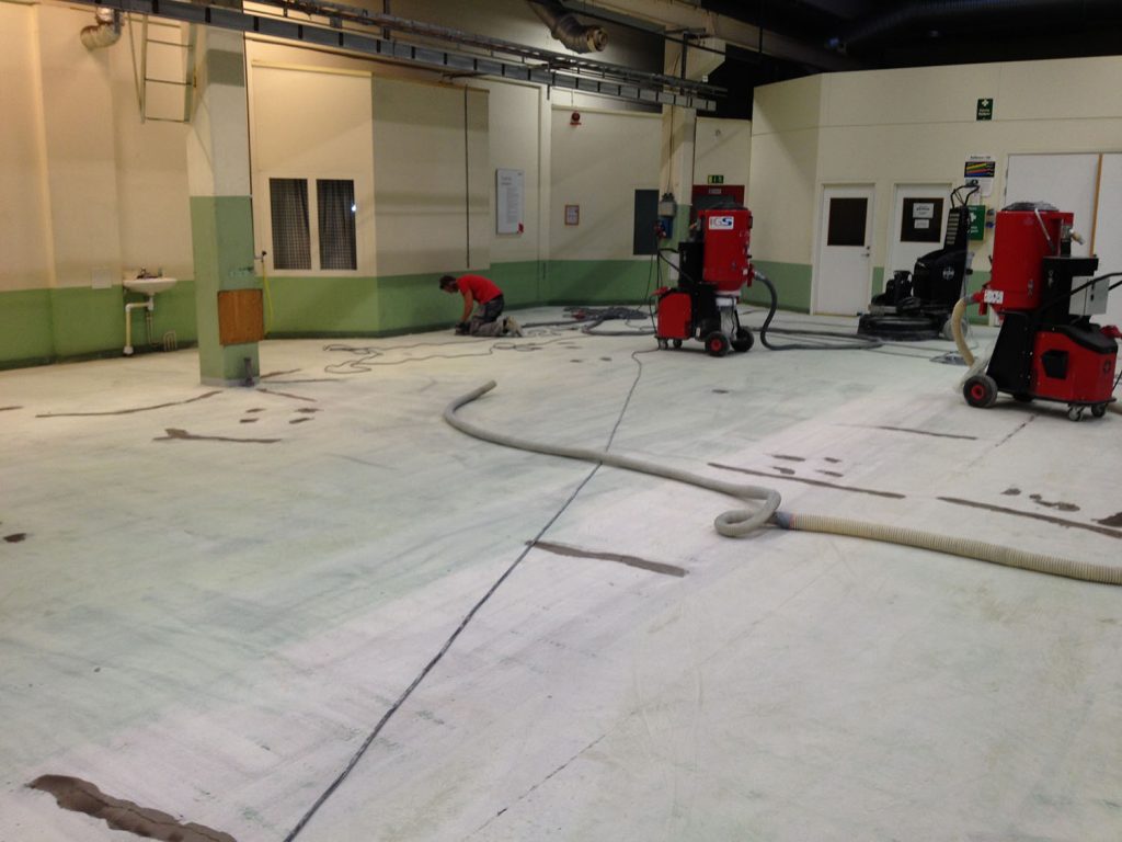 Betonggolv rengjort och förberett för reparation och spackling.
