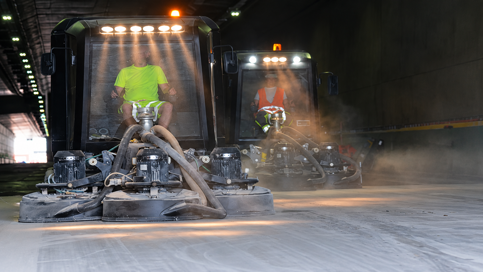 Betongslipning inom infrastruktur med två stora slipmaskiner
